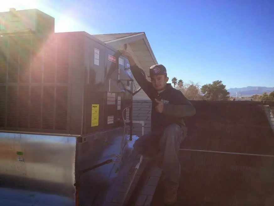 HVAC technician performing AC Tune-Up on a rooftop unit in Calumet Park
